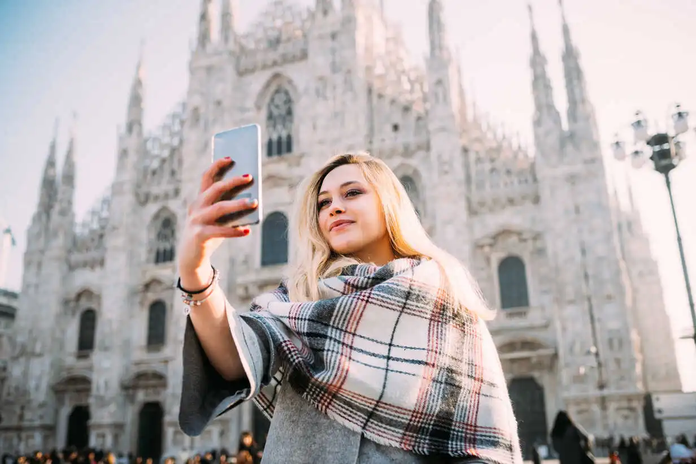young-female-tourist-taking-smartphone-selfie-in-front-of-milan-cathedral-milan-italy-CUF51381.webp